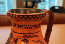 Ανάμεσά τους ακέφαλο άγαλμα του Ερμή και ανάγλυφο της θεάς Aθηνάς